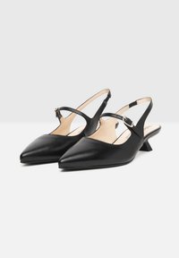 Sorte læderslingback-sko med spidse tæer, lav blokhælk, og justerbar ankelrem. Glat tekstur, minimalistisk design.