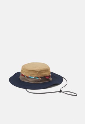 Bucket-Hut mit einem khakifarbenen Oberteil und einem breiten marineblauen Rand. Beinhaltet ein gemustertes Stoffband um die Basis. Verfügt über einen verstellbaren Kordelzug.