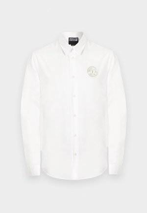 Bela srajca z dolgimi rokavi in gumbi ter koničastim ovratnikom z okroglim logotipom Versace Jeans Couture na levem prsnem delu.