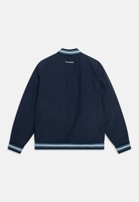 Granatowa kurtka bombowca z elastycznymi mankietami i dołem, z paskowanym kołnierzem i haftowanym logo "Converse" na plecach.