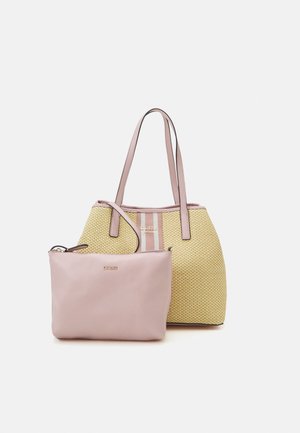 Sac cabas tissé beige avec des anses roses et un détail rayé, assorti d'une petite pochette rose zippée, tous deux avec le logo Guess.
