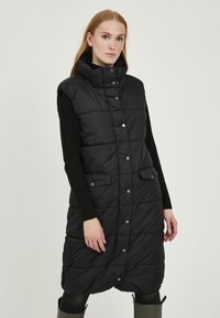 Gilet imbottito nero con colletto alto, bottoni a pressione e due tasche frontali. Presenta un design trapuntato ed è di lunghezza al ginocchio.