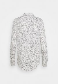 Camicia a maniche lunghe in tessuto bianco con motivo floreale nero, colletto con bottoni, orlo arrotondato e polsini con bottoni.