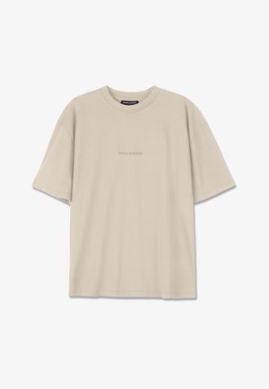 Beige színű pamut póló rövid ujjakkal, kerek nyakkivágással és egy diszkrét, dombornyomott "PEGADOR" logóval az elülső részen. Sima textúra.