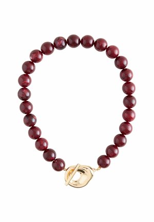 Round dark red beaded bracelet with a large irregular gold toggle clasp on a white background.
