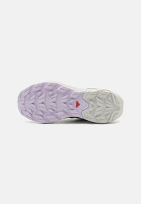 Semelle d'une chaussure de course avec un motif de semelle en violet clair et gris conçu pour l'adhérence et la traction en extérieur sur fond blanc.