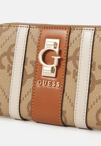 Brown canvas wallet with a gold logo and brown leather accent. Features light beige stripes and a textured pattern throughout.