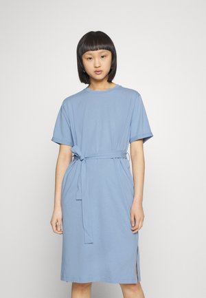 Vestido azul claro feito de um tecido suave, com mangas curtas, um cinto de laço na cintura e fendas laterais para facilitar o movimento.