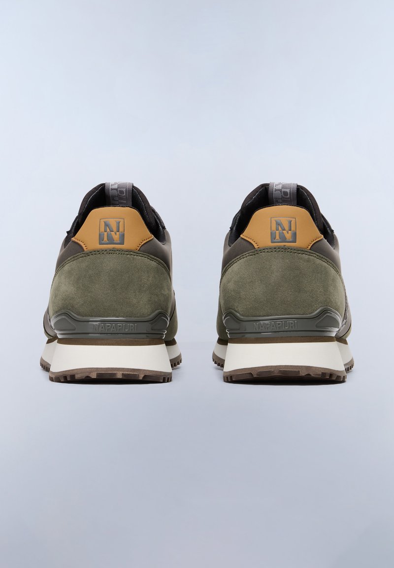 Zapatillas deportivas verdes y negras con acabado de ante, que cuentan con un acento beige en el talón, suela de goma y un logotipo grabado en la parte trasera.