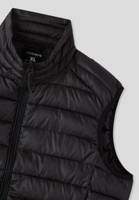 Gilet imbottito nero senza maniche con colletto alto, design trapuntato, zip frontale e aperture elastiche per le braccia. Il materiale sembra lucido e liscio.
