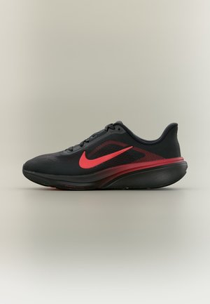 Čierno-červená bežecká topánka Nike s červeným logom swoosh, tlmenou podrážkou a sieťovinovým zvrškom, zobrazena z bočného profilu na neutrálnom pozadí.