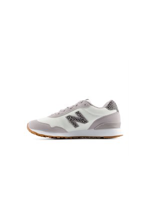 Baskets New Balance blanches et gris clair avec des accents imprimé léopard et une semelle couleur gomme, présentées en profil latéral sur fond blanc.
