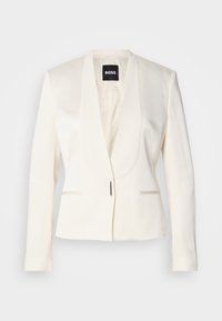 Blazer ajustado em creme com um decote em V profundo, lapelas finas, dois bolsos frontais e fecho de gancho único. Textura suave e corte estruturado.
