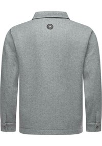 Gray wool jacket with a collar, long sleeves, and a rounded hem. Features a button at the back and snap fasteners on the cuffs.