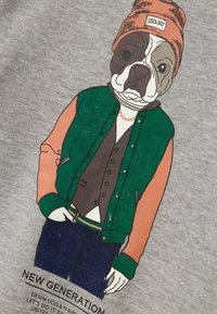 Gráfico de un perro con una chaqueta verde y naranja, un chaleco marrón y un gorro naranja. El texto dice "NUEVA GENERACIÓN" debajo del personaje.