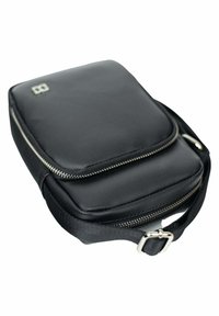 Sacoche noire en nylon avec une surface texturée, deux compartiments zippés et une sangle avec boucle en métal. Présente un logo discret à l'avant.