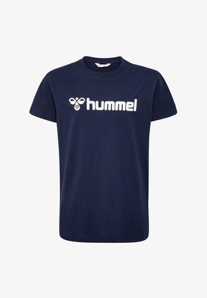 Dwoje dzieci w granatowych koszulkach hummel i szarych dresach stoi uśmiechniętych, jedno z szeroko rozstawionymi nogami, drugie lekko odchylone do tyłu.