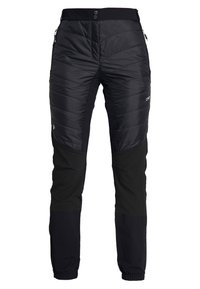 Pantaloni neri isolati con design trapuntato nella sezione superiore, tessuto liscio nella parte inferiore, cintura elastica e tasche con zip sui lati.