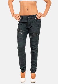 Jeans skinny neri in camouflage con numerose tasche con zip, un design aderente e dettagli di cucitura a contrasto. Tessuto liscio.