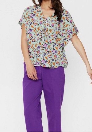 Blusa de manga corta y escote en V en verde menta con un patrón floral en púrpura, naranja y rosa. Combinada con pantalones de pierna ancha sólidos en púrpura.