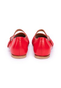 Rote Leder-Schuhe mit glatter Textur, runder Form und Knöchelriemen. Mit einer silbernen Schnalle und einer hellbraunen Sohle.