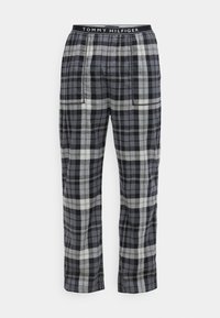 Calças xadrez nas cores preto, cinza e branco, com um cós elástico e o logótipo "TOMMY HILFIGER", corte reto e bolsos laterais.