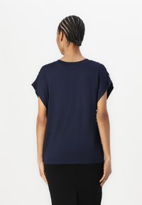 Marineblaues Kurzarm-T-Shirt mit Rundhalsausschnitt, locker geschnitten und mit glatter Textur, entworfen für angenehmen Tragekomfort.