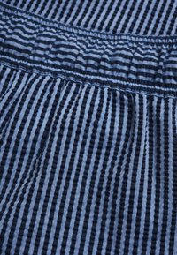 Tessuto a righe blu con linee sottili e spesse alternate, caratterizzato da una superficie testurizzata e una vita arricciata per elasticità.