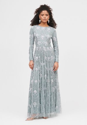 Long-sleeved, floor-length dress in soft blue with intricate silver beadwork and floral patterns. Flowy textured fabric with gathered waist.