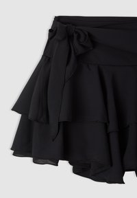 Gonna nera a strati in tessuto leggero, con coulisse in vita e orlo arricciato, rifinita con texture e bordi cuciti.