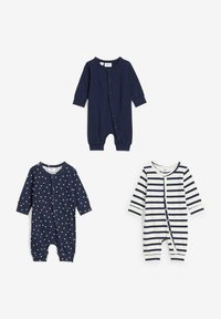 Tre tutine per neonati: a sinistra in navy con pois bianchi, al centro in navy a tinta unita, a destra in righe navy e bianche. Tutte presentano chiusure a pressione sul davanti.