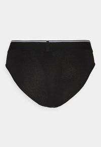 Sorte undertøj med en glat tekstur, prydet med en bred sort elastik med hvide striber. Bagfra fremhæver det en enkel design.