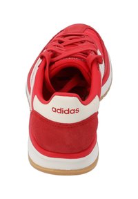 Rode Adidas sneaker met een bovenwerk van suede, witte accenten, een gewatteerde kraag en een rubberen zool. Veters en het merklogo zichtbaar op de hiel.