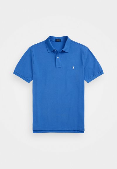 Zila kokvilnas polo krekls ar klasisku apkakli un īsām piedurknēm, kuram uz krūtīm ir neliels izšūts logos.