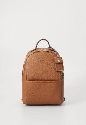 Small brown leather backpack with front pocket, gold zipper, top handle, and attached matching leather tag on white background.