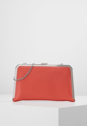Rød rektangulær clutch-taske med sølvramme og kæderem, hvilende på hvid overflade mod ensfarvet baggrund.