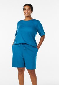 Blaues kurzärmeliges Oberteil mit rundem Ausschnitt, kombiniert mit passenden Shorts mit verstellbarem Kordelzug, aus weichem, leichtem Stoff gefertigt.