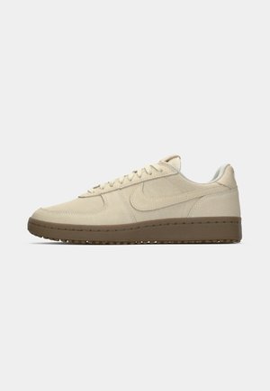 Sneaker in suede beige con design a low-top, caratterizzate da punta rotonda, chiusura con lacci e suola in gomma marrone.