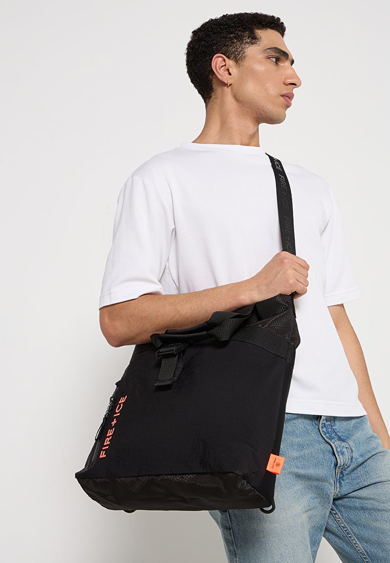 Schwarze Schultertasche mit strukturierter Oberfläche, verstellbarem Riemen, orangefarbenen Logoakzenten und einer strukturierten rechteckigen Form.