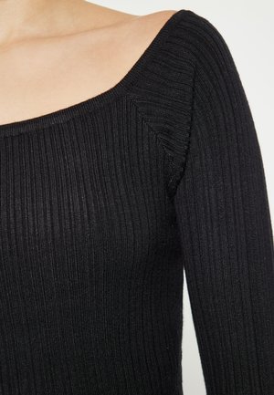 Czarny longsleeve wykonany z prążkowanej dzianiny, z kwadratowym dekoltem i dopasowaną sylwetką, z dyskretnym detalem szwów.