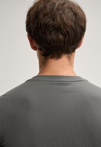 Grijze short-sleeve shirt van ribstof. Heeft een ronde halslijn en een gladde textuur, met een eenvoudig en modern ontwerp.
