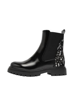 Bottines noires avec une finition laquée brillante, des panneaux latéraux élastiques, et un accent texturé noir et blanc au niveau du talon. Semelle en caoutchouc épaisse.