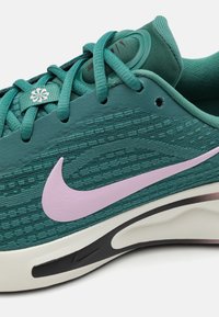 Tirkizne Nike trkaće cipele s teksturiranom tkaninom, lavanda swoosh logom, tirkiznim vezicama i podstavljenim bijelim đonom s crnim detaljima.