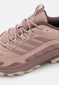 Svijetloružičasta trail tenisica izrađena od mrežastih i antilop materijala. Sadrži oblikovani uzorak, ojačani vrh i kontrastni gumeni potplat.