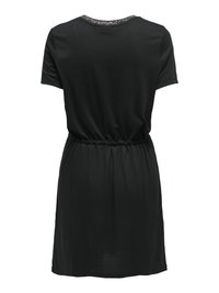 Robe noire à manches courtes avec taille élastique, encolure ronde ornée d’un léger liseré scintillant, ourlet à hauteur du genou, vue de dos.