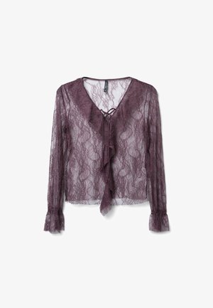 Blusa in pizzo di un lilla tenue con maniche lunghe, scollatura con rouches, chiusura con fiocco e polsini arricciati, caratterizzata da intricate fantasie floreali.