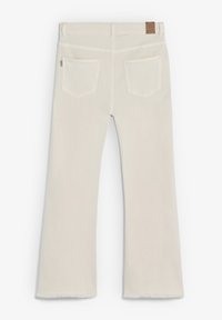 Pantalones de mezclilla blancos acampanados con un dobladillo deshilachado, que cuentan con dos bolsillos traseros y una etiqueta de cuero marrón en la cintura.