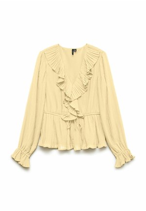 Blouse beige à manches longues avec tissu plissé, encolure en V à volants et poignets, et détail de taille à cordon.
