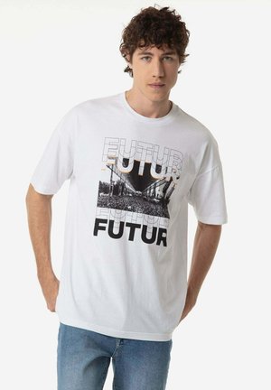 Camiseta de algodón blanca con un estampado gráfico de la palabra "FUTUR" en negro y naranja, con una imagen de una multitud debajo de una estructura arquitectónica.