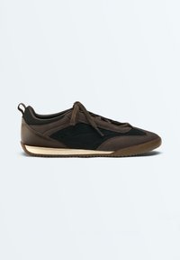 Baskets marron et noires avec panneaux latéraux en mesh, fermeture à lacets à l'avant, semelle beige profil bas et languette au talon, vues de profil droit.